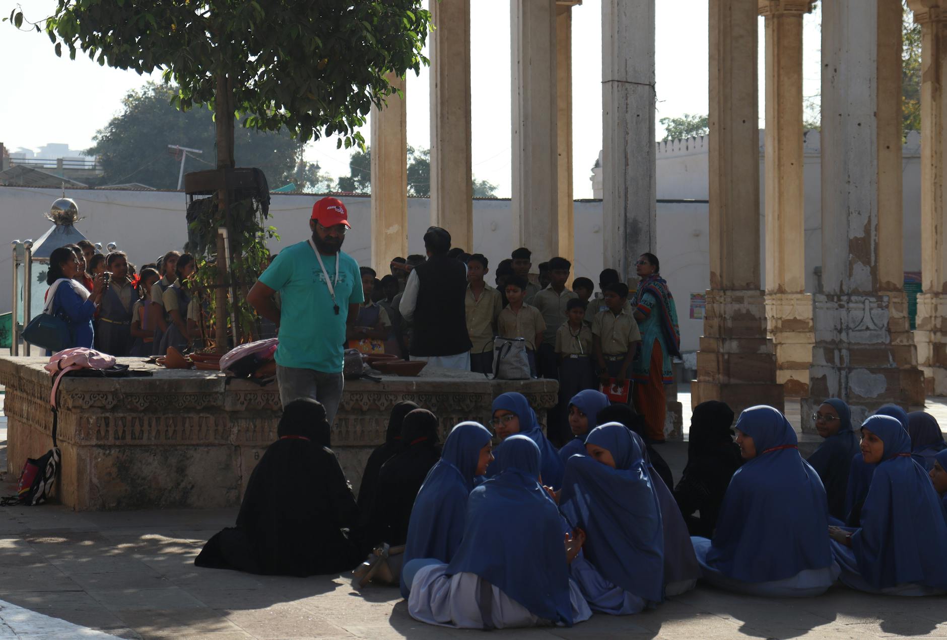 Uczniowie w szkolnych mundurkach zwiedzają zabytkowy obiekt z kolumnami