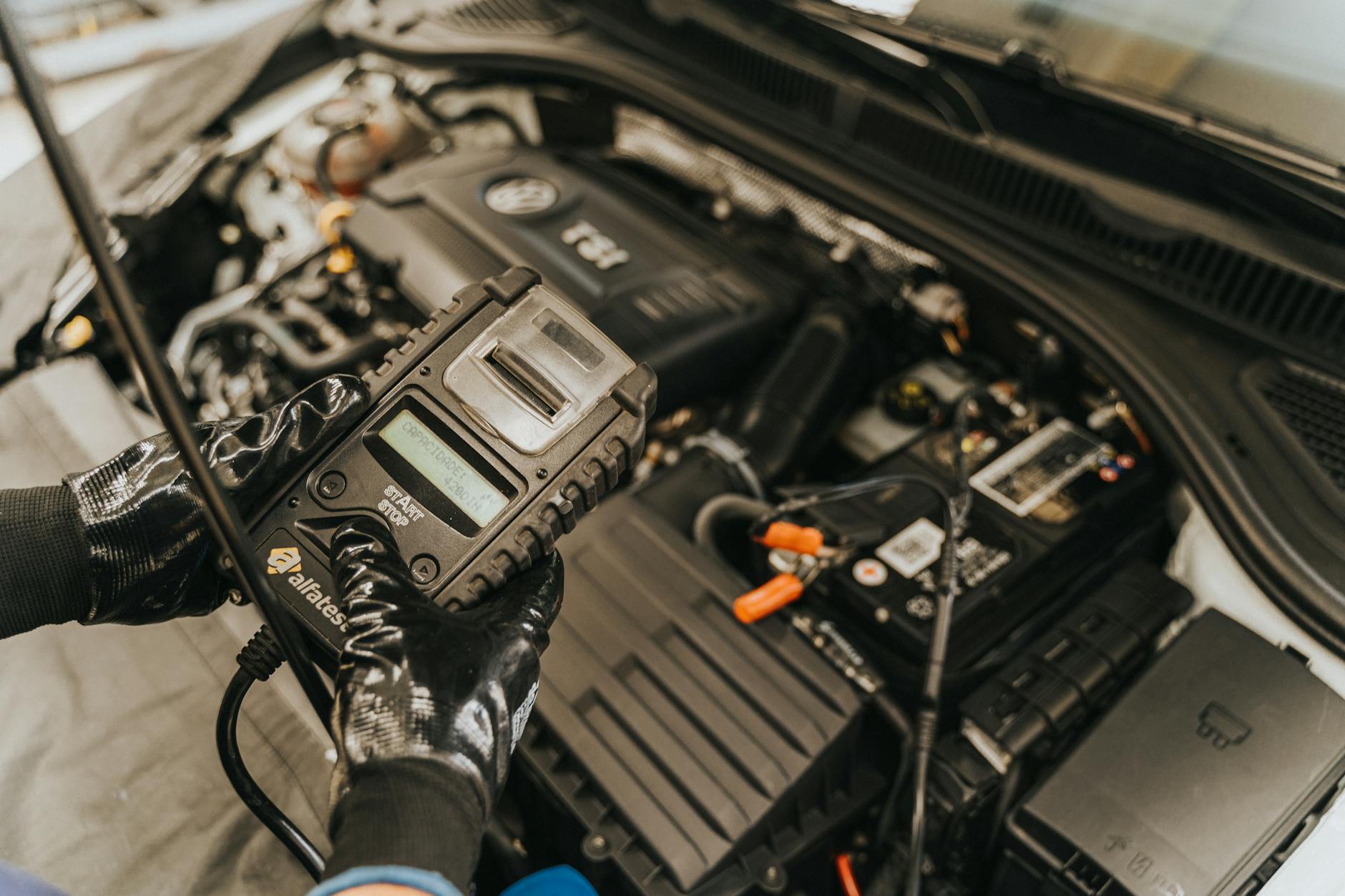 Mechanik diagnozuje instalację elektryczną silnika testerem samochodowym