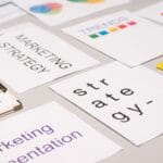 Dokumenty strategii marketingowej i wykresy na biurku widziane z góry