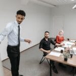 Różnorodny zespół współpracuje i rozmawia w nowoczesnym biurze